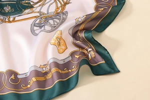 Detailed macro shot of satin scarf featuring equestrian prints and fine silk texture