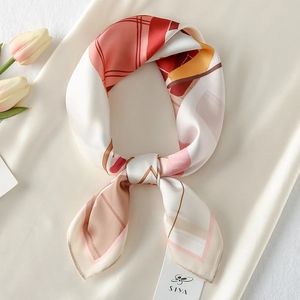 Close-up of silk-satin square scarf with red geometric patterns and floral tulip accents