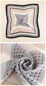 Dettaglio della texture lucida e dei motivi geometrici del foulard in raso