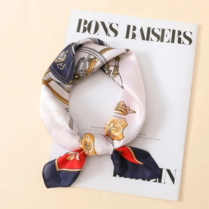 Close-up of elegant floral print satin scarf styled over a French fashion magazine
