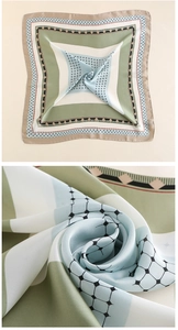 Dettaglio di un foulard in raso geometrico con elegante color blocking e trama setosa