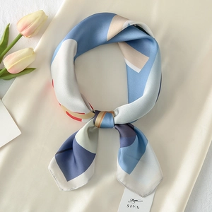 Detailed view of artistic geometric pattern silk scarf with elegant knotted styling