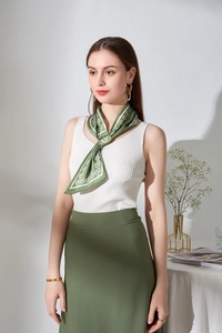 Dettaglio di un elegante foulard in seta verde con motivo floreale annodato