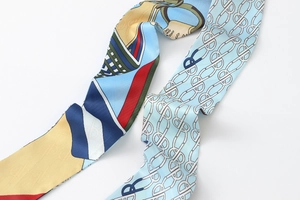 Detailed close-up of double-sided satin twilly scarf with blue floral and geometric patterns