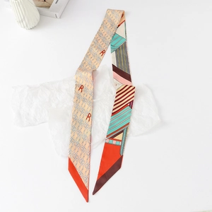Close-up of narrow silk scarf with retro chain patterns and orange geometric blocks