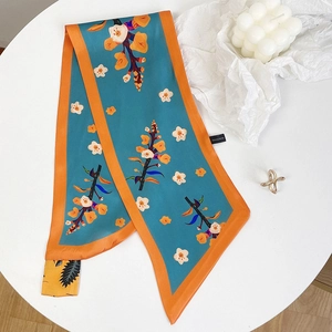 Dettaglio ravvicinato dell'etichetta 100% poliestere su un foulard di seta a fiori sottile