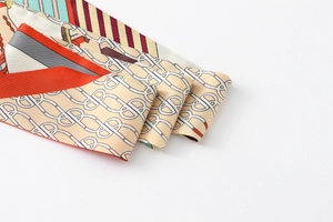 Detail of satin floral twilly scarf featuring TB monogram and vibrant striped pattern