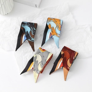 Detailed view of four colorful marble pattern silk twilly scarves on white paper