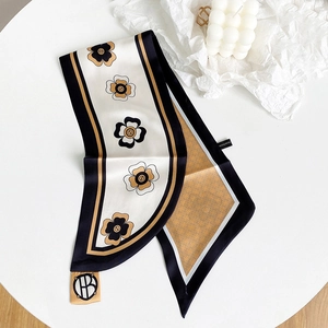 Dettaglio foulard in seta con stampe floreali eleganti e fibbia con logo HB oro