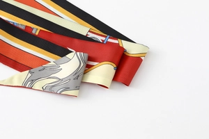 Detail of floral skinny silk scarf showing elegant flowing lines and vibrant geometric patterns