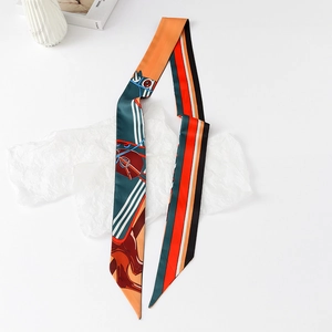 Detailed view of long narrow twilly scarf with equestrian horse head and chain patterns
