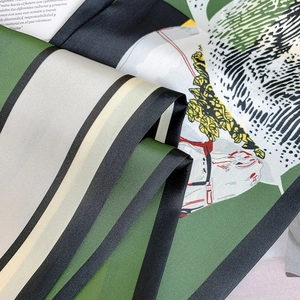 Detailed close-up of forest green silk scarf with horse print and striped borders