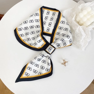 Elegante foulard in seta con stampa a farfalla e bordo giallo su un tavolo decorativo
