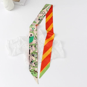 Close-up of narrow silk-like twilly scarf featuring green cartoon floral and orange diagonal stripes