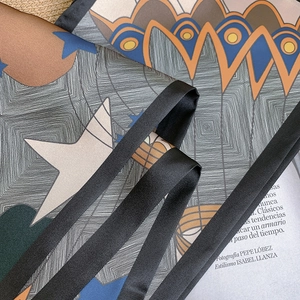 Macro detail of ink painting silk scarf with geometric star patterns and orange accents