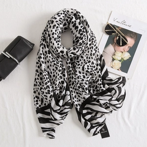 Detailed texture of leopard and zebra print scarf with stylish brand tag and accessories