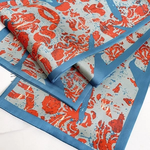 Close-up of ink painting silk scarf with grey-blue tones and orange abstract patterns