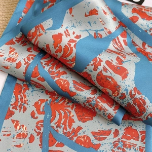 Detailed close-up showing the sky blue silk texture and abstract coral pattern design