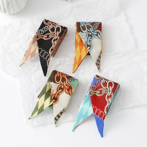 Detail of four narrow floral silk scarves with classic metal chain and diamond patterns