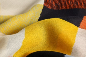 Close-up of colorful geometric pattern scarf showing fine linen-touch fabric texture