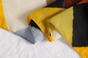 Detailed view of colorful geometric diamond pattern fabric with delicate hemmed edges