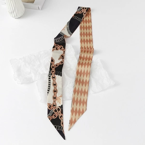 Detail of double-sided floral twilly scarf with chain and diamond patterns on white paper