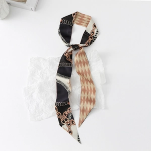 Detail of a double-sided twilly scarf featuring gold chain and diamond lattice patterns
