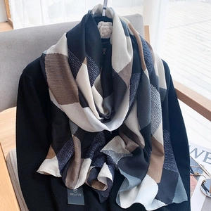 Detail of color-block geometric scarf with thick texture and neutral tones