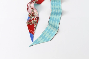 Close-up of double-sided silk-like scarf with chain patterns and green rhombic textures