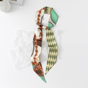 Detail of narrow silk scarf with diamond check pattern and gold chain motifs on textured paper
