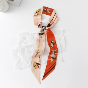 Detail of red and beige floral horse print skinny silk scarf tied on artistic paper