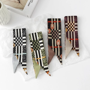 Flat lay of narrow floral twilly scarves in four retro patterns with smooth silk-like texture