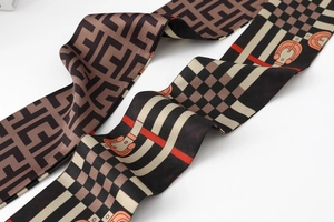 Macro shot of faux silk twilly scarf with equestrian horse-bit patterns and geometric motifs