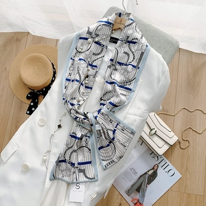 Close-up of elegant digital ink silk scarf with horsebit chain and blue edges