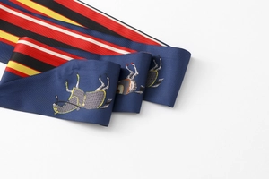 Detail of navy blue silk ribbon scarf featuring vintage horse prints and striped patterns