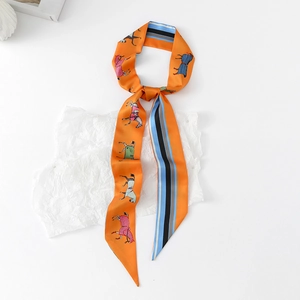 Close-up of vibrant orange equestrian twilly scarf featuring horse motifs and stripes