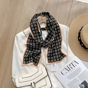Vue détaillée d'un foulard en satin à rayures noires avec bordure orange sur blazer