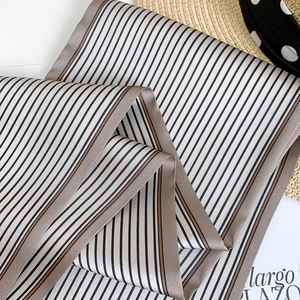 Détail du foulard en satin rayé gris avec des bords ourlés sur un chapeau français