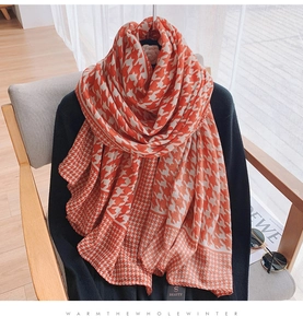 Detailed texture of thick red houndstooth cotton linen scarf draped on a chair