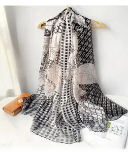 Detailed view of lightweight beach shawl with polka dots and classic plaid prints