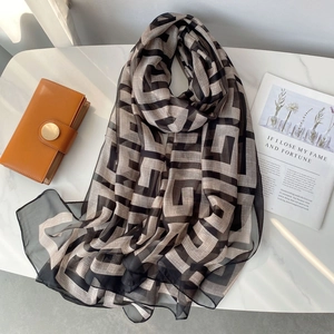 Detail of soft chiffon scarf with double F geometric pattern on marble background