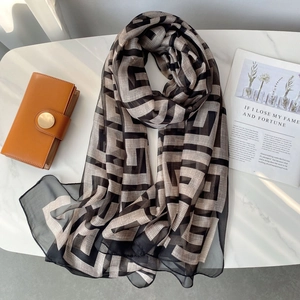 Macro detail of elegant chiffon shawl with classic black and beige geometric patterns
