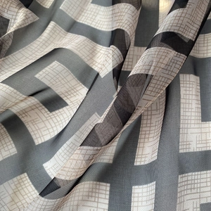 Macro detail of breathable chiffon beach scarf featuring geometric L-pattern print