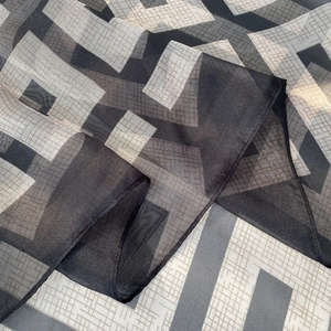 Detail of sheer polka dot beach shawl showing geometric patterns and soft texture