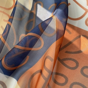 Close-up of lightweight polka dot beach scarf with navy and orange color blocks