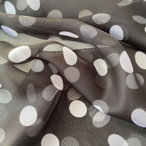 Detailed view of lightweight polka dot fabric with soft draping and sheer chiffon texture