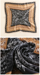 Close-up of silk square scarf featuring vintage paisley and botanical patterns with gold borders