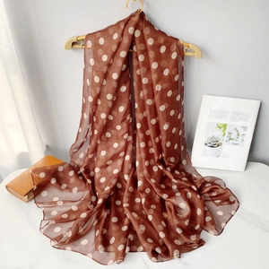 Detail shot of lightweight brown polka dot chiffon scarf with soft drape and textures