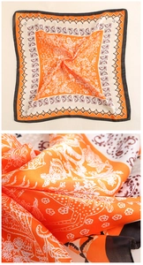 Detail of vintage paisley silk scarf with gold borders and bright orange floral patterns