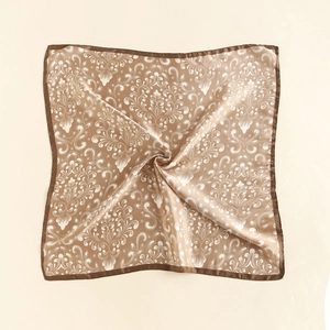 Macro detail of silk-like square scarf featuring baroque floral patterns and golden edges